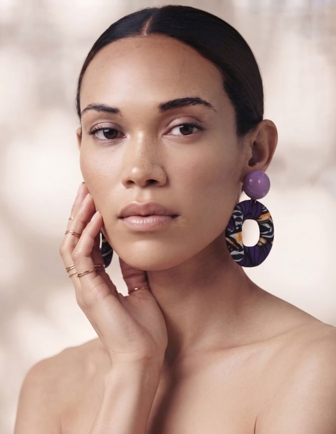 Femme avec un chignon portant des boucles d'oreilles pendantes en tissu wax