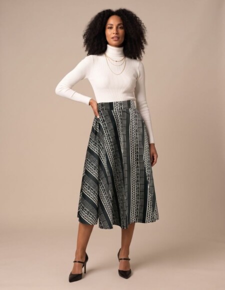 Femme portant une jupe patineuse mi-longue en bogolan noir et blanc aux motifs géométriques, taille unique extensible