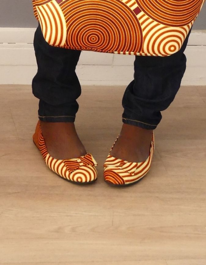 Pieds de femme portant des sandales plates en wax rouge et beige, taille 38