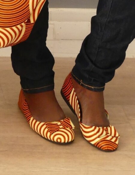 Pieds de femme portant des Ballerines plates en wax rouge et beige, taille 38