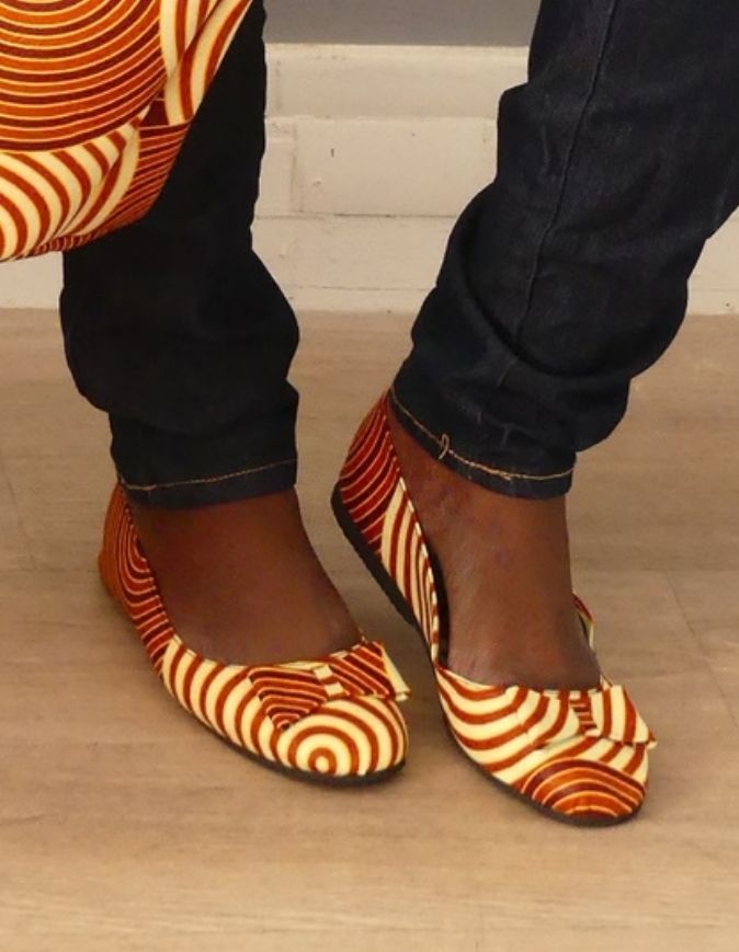 Pieds de femme portant des Ballerines plates en wax rouge et beige, taille 38